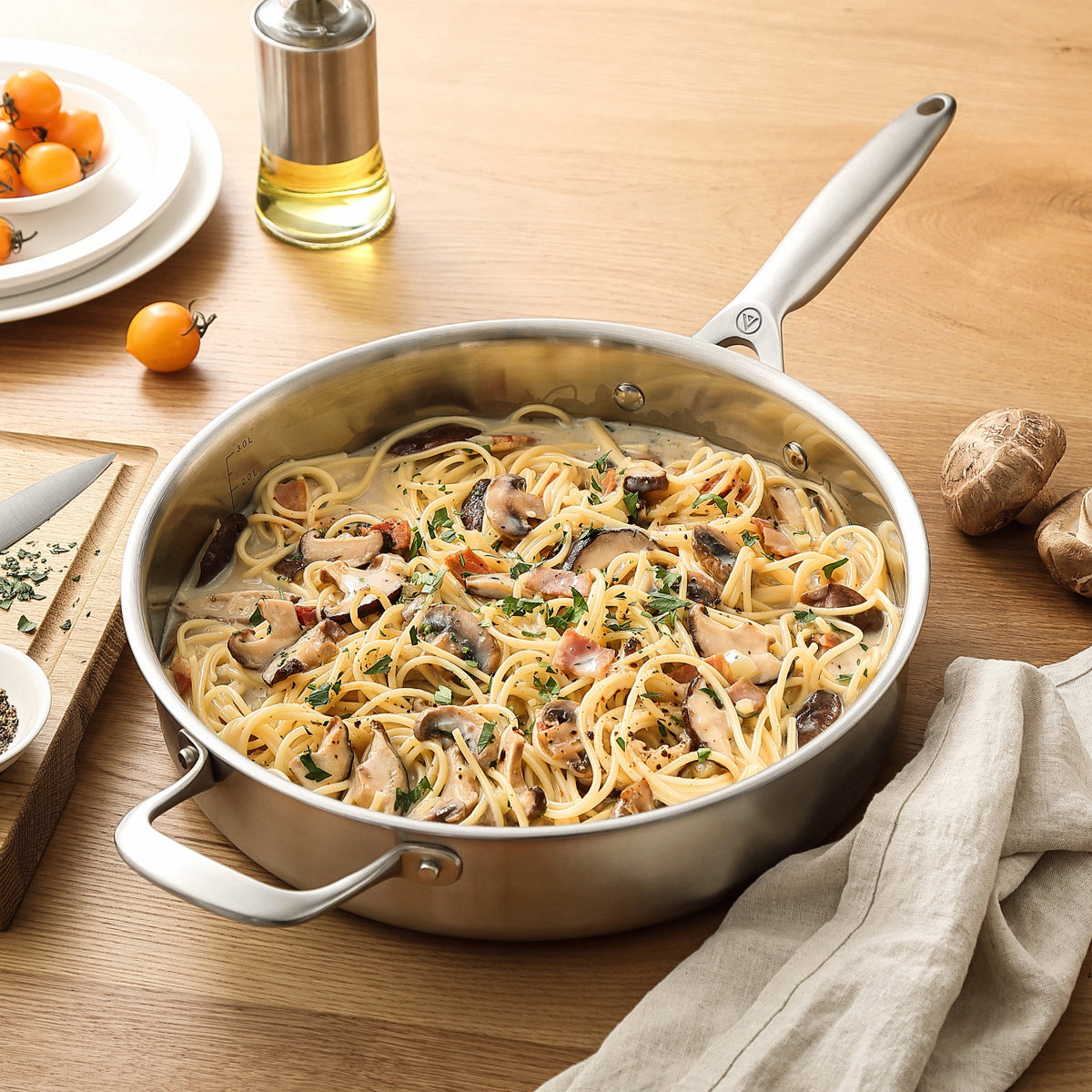 Pasta med svampe i sauterpande i 3-Ply rustfrit stål på træbord
