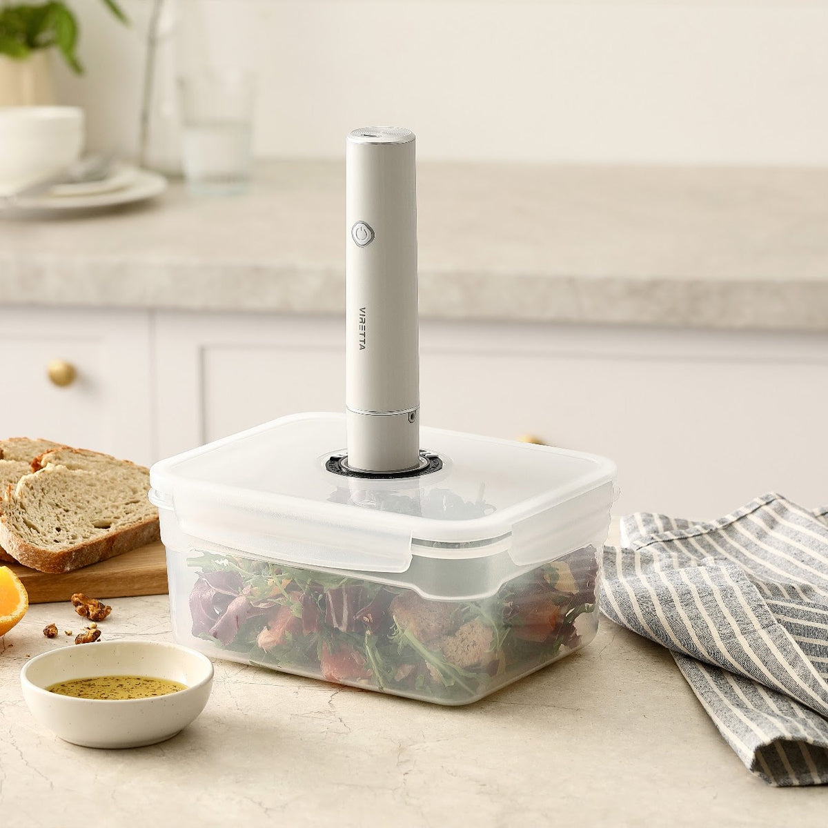 Den elektriske vakuumpumpe sat på låget af en vakuumbeholder i plast med salat