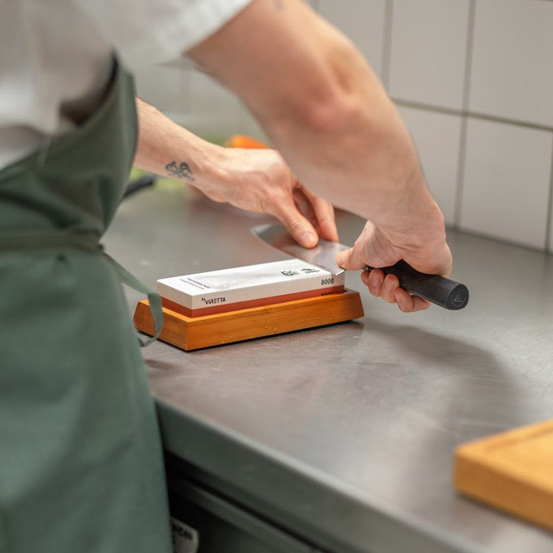 En kniv slibes på Shōjin slibesten 3000/8000 i bambusholderen i et restaurantkøkken