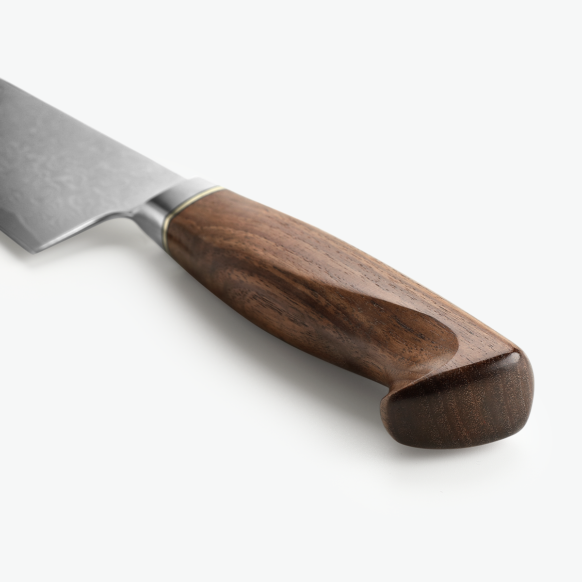 Det skulpturelle valnøddegreb på Shōjin Kaku gyuto, set skråt bagfra