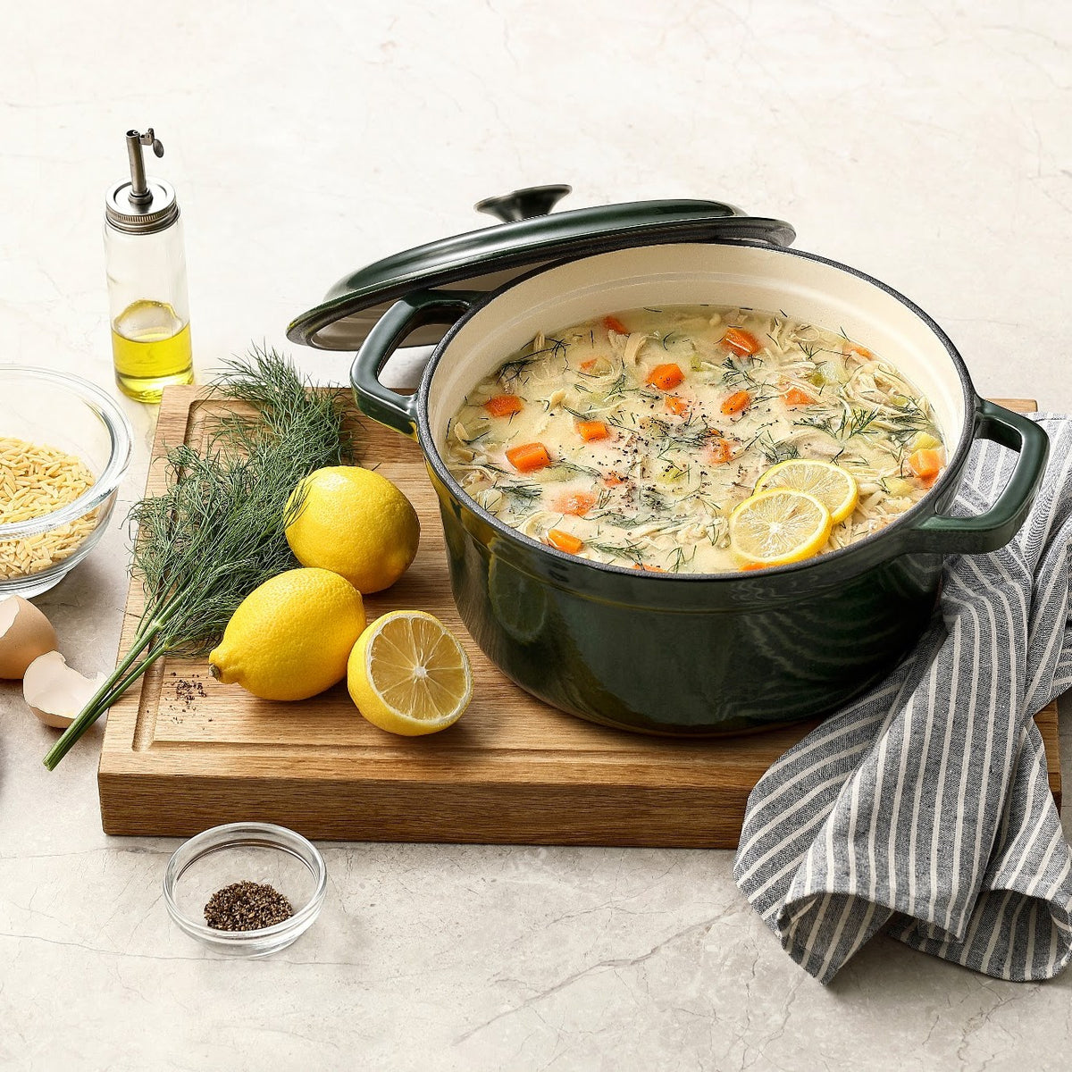 Mosgrøn støbejernsgryde med kyllingesuppe, citron og dild, låget på skrå, på skærebræt