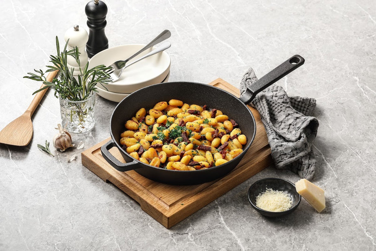 Gnocchi i en støbejernspande på et skærebræt i træ