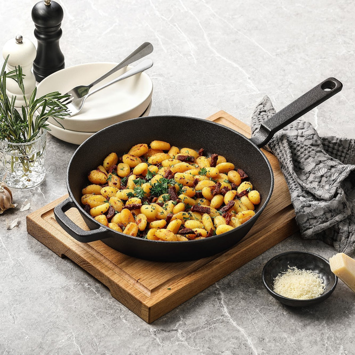 Støbejernspande i råt støbejern med stegte gnocchi, på skærebræt