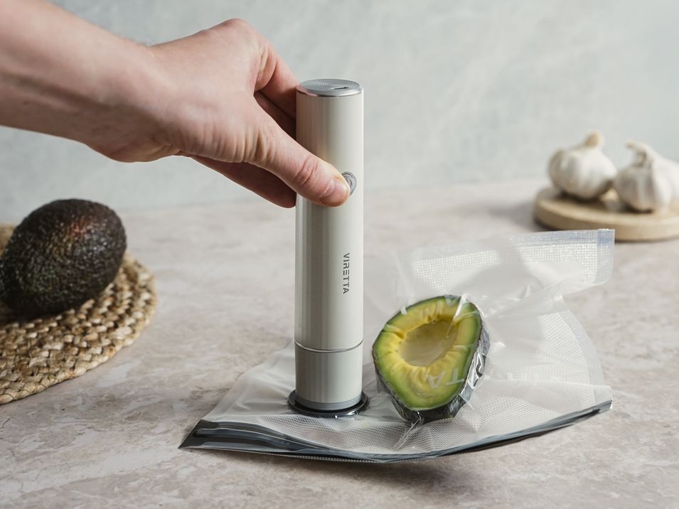 En vakuumpumpe og en beholder med en halv avocado på et køkkenbord