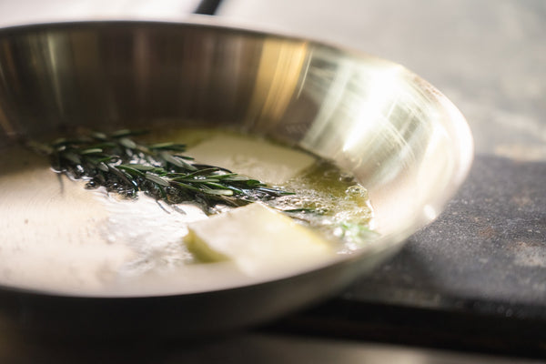 Smør og rosmarin i en stegepande af rustfrit stål